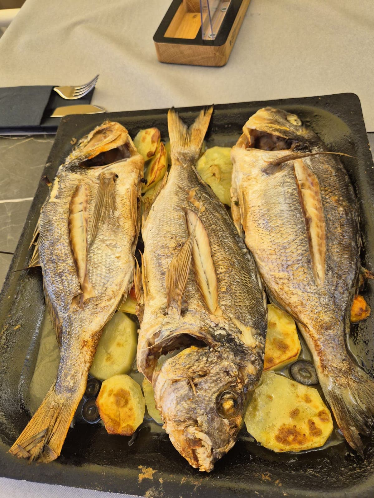 Pečene orade s krumpirom – Oli Mare Pečene orade s krumpirom na crnom pladnju – domaći istarski riblji specijalitet, Poreč | baked sea bream with potatoes Porec